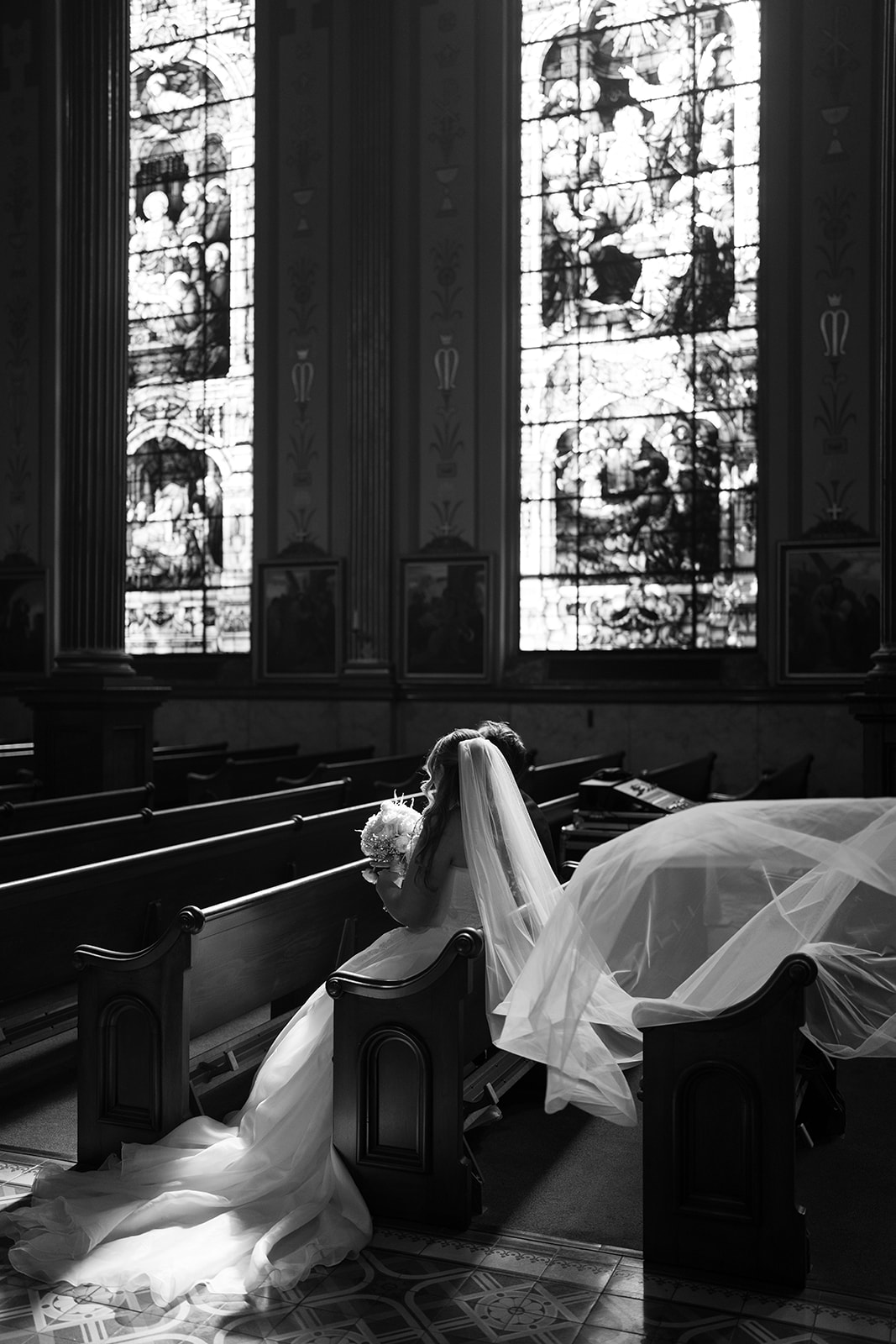 Black-and-white bridal portrait of Hannalee seated beneath her veil in the church