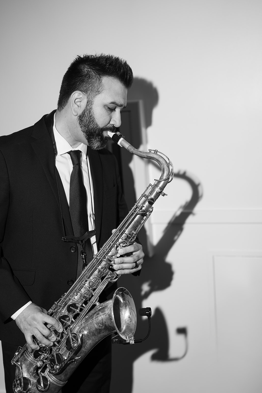Black-and-white photograph of a saxophonist performing during the reception