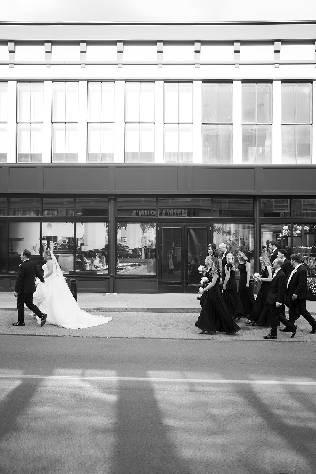 Black-and-white photograph of the wedding party crossing a Covington street
