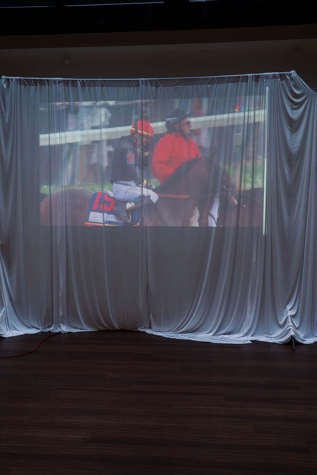 Projected video playing on a draped wall during the reception