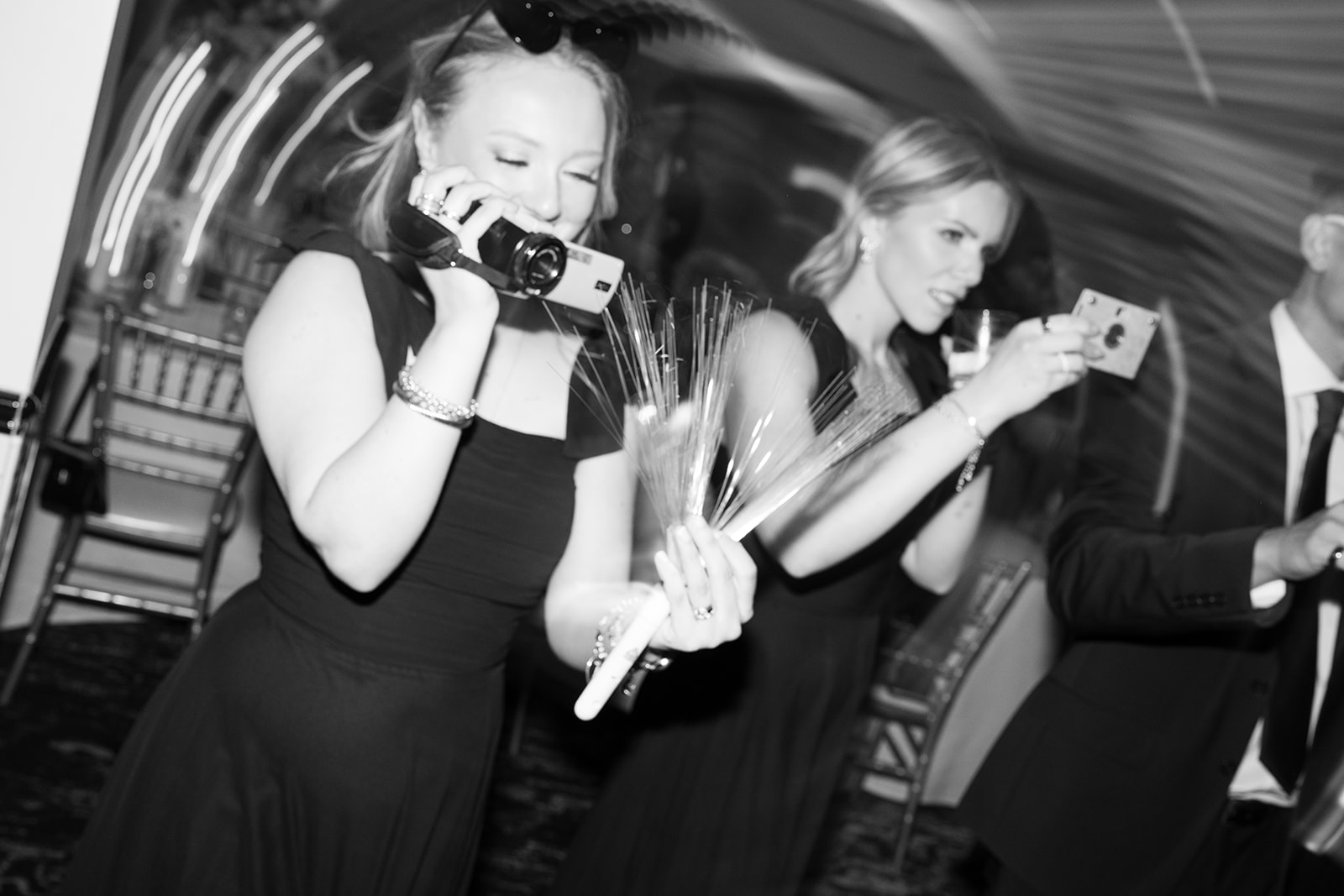 Black-and-white candid of guests using cameras on the dance floor