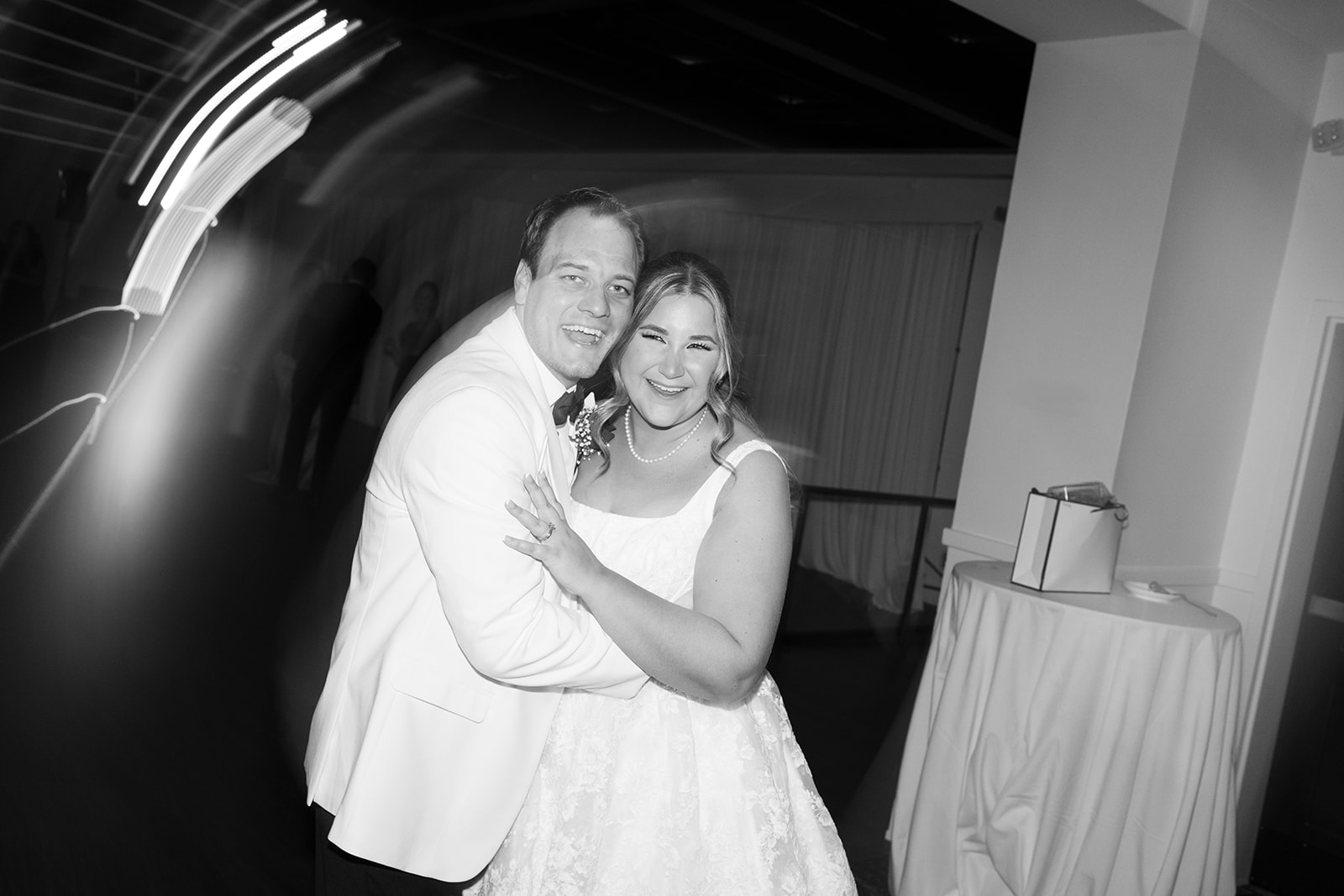Black-and-white photograph of Ben and Hannalee embracing during the party