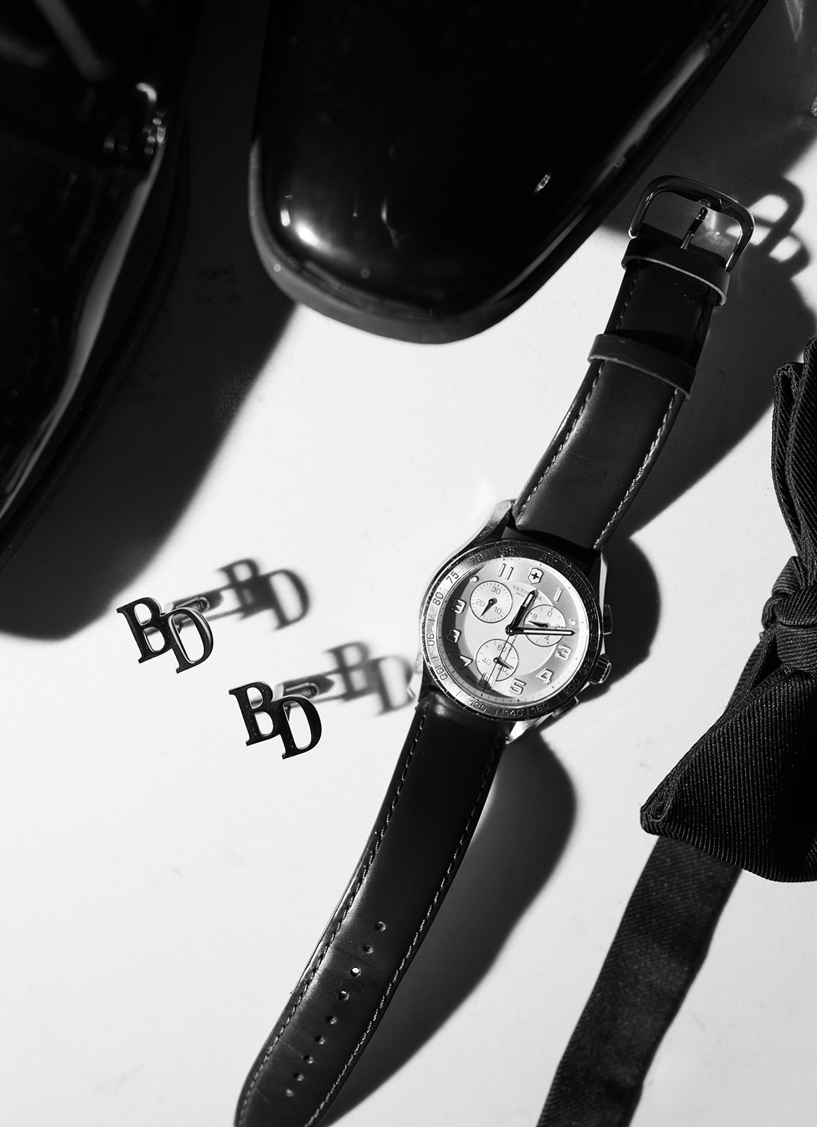 Black-and-white detail of Ben's watch and monogrammed cufflinks