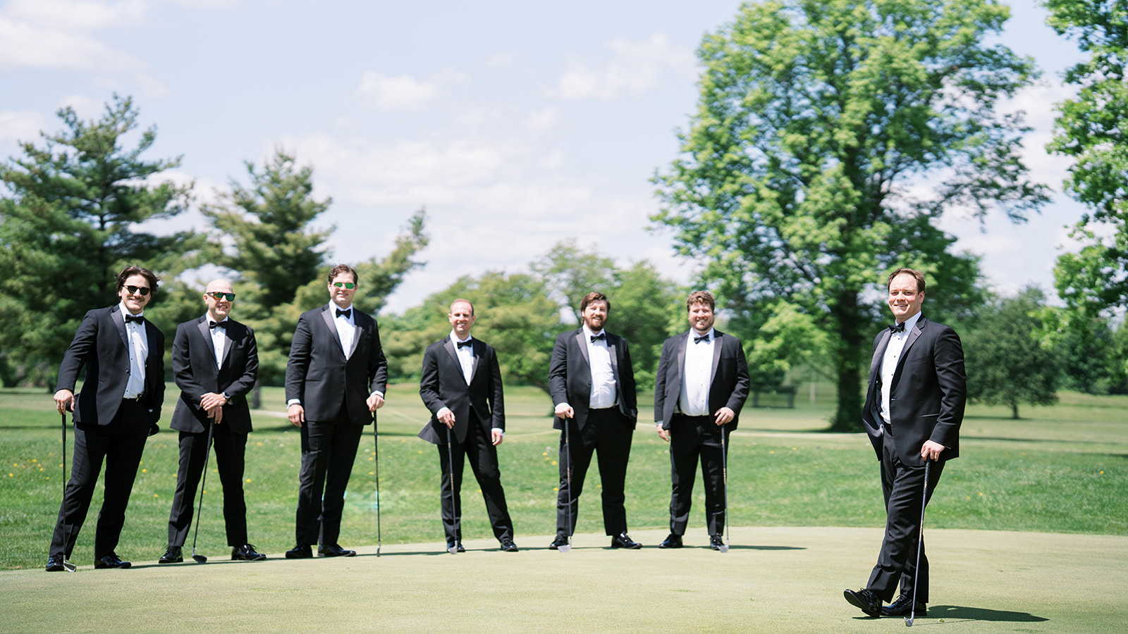Ben and his groomsmen standing together on a putting green