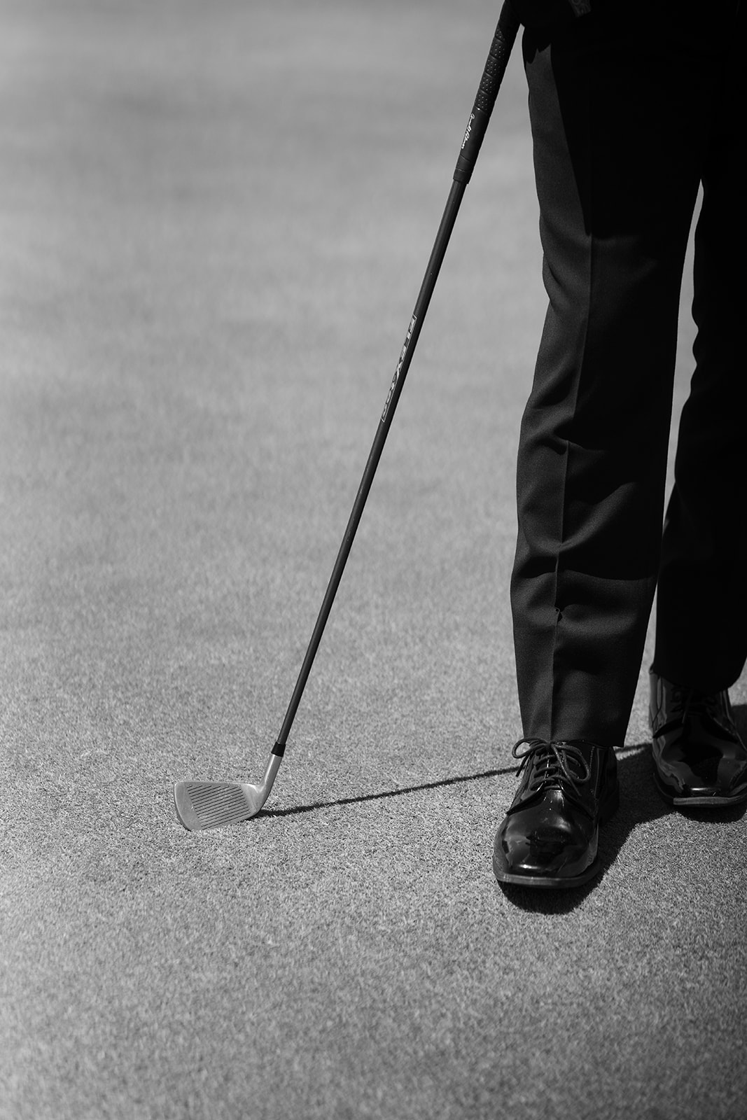 Black-and-white detail of Ben lining up a putt