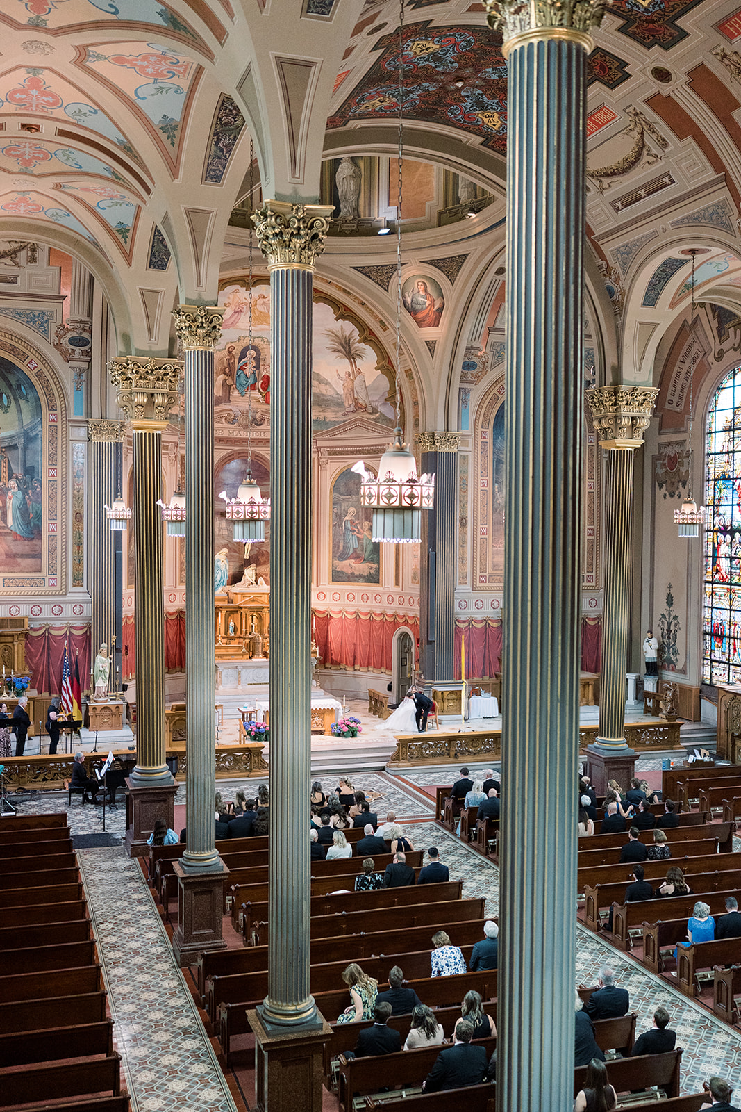 Ceremony view framed by tall columns inside Mother of God Church