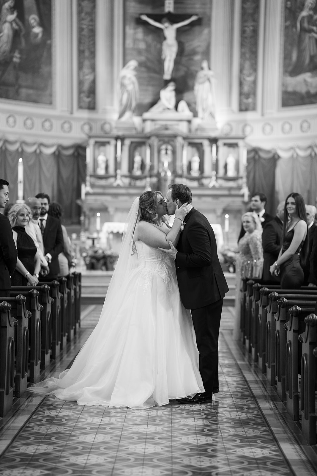 Black-and-white photograph of Ben and Hannalee kissing during the ceremony