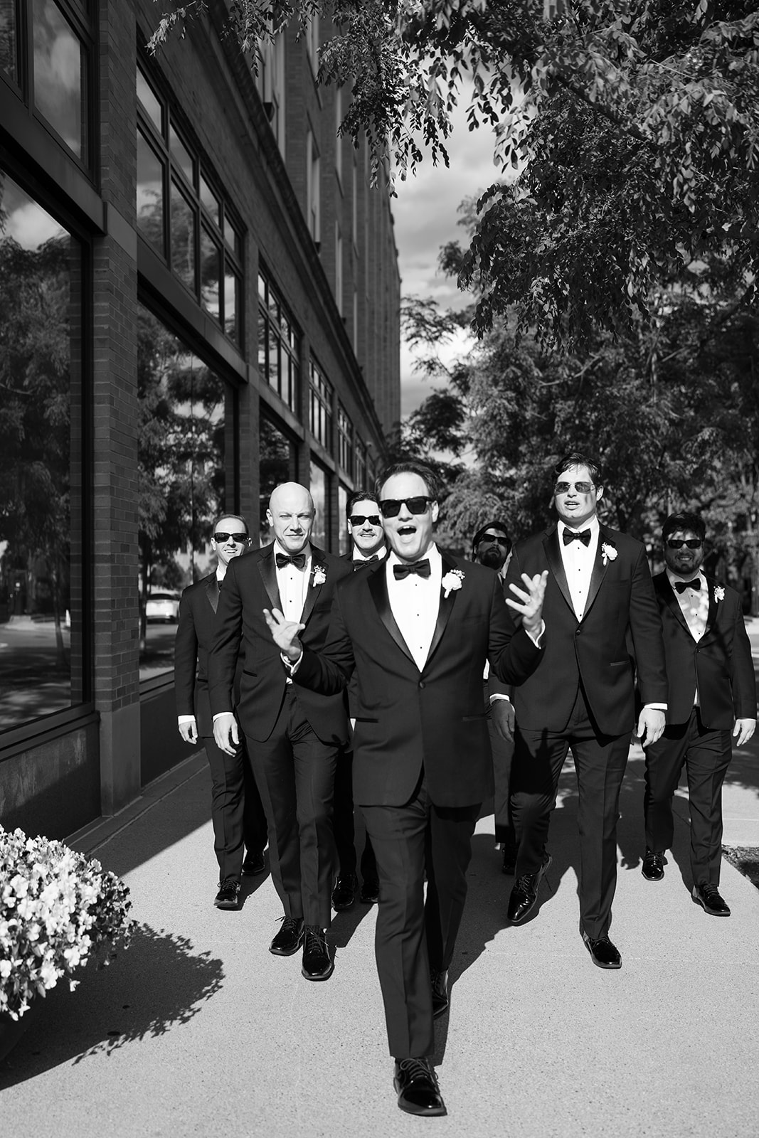 Black-and-white photograph of the groomsmen walking outside Hotel Covington