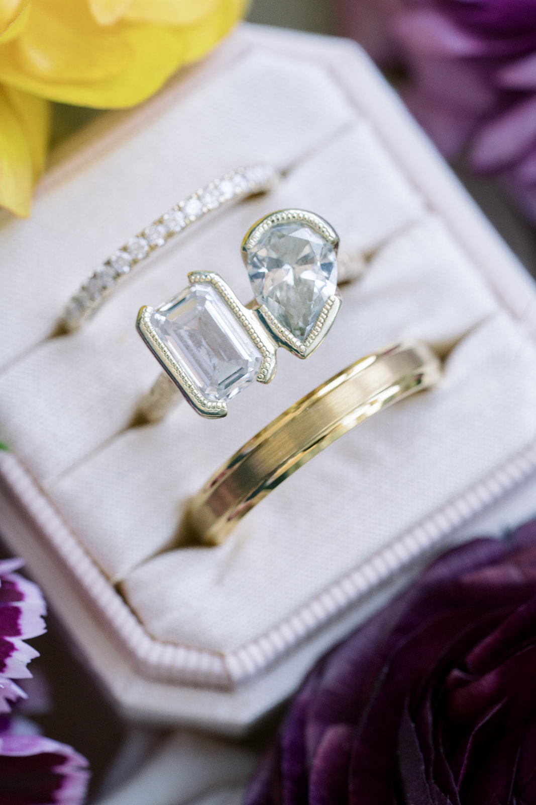 Jeff and Breanna's wedding rings arranged in a ring box among colorful flowers