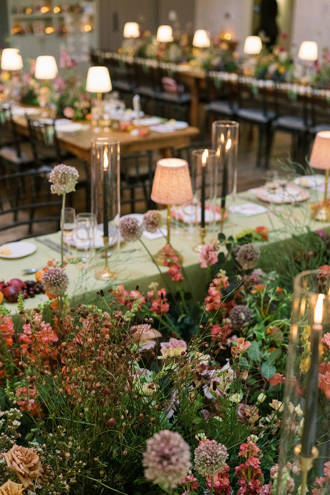 Garden-inspired reception tables with flowers and small lamps