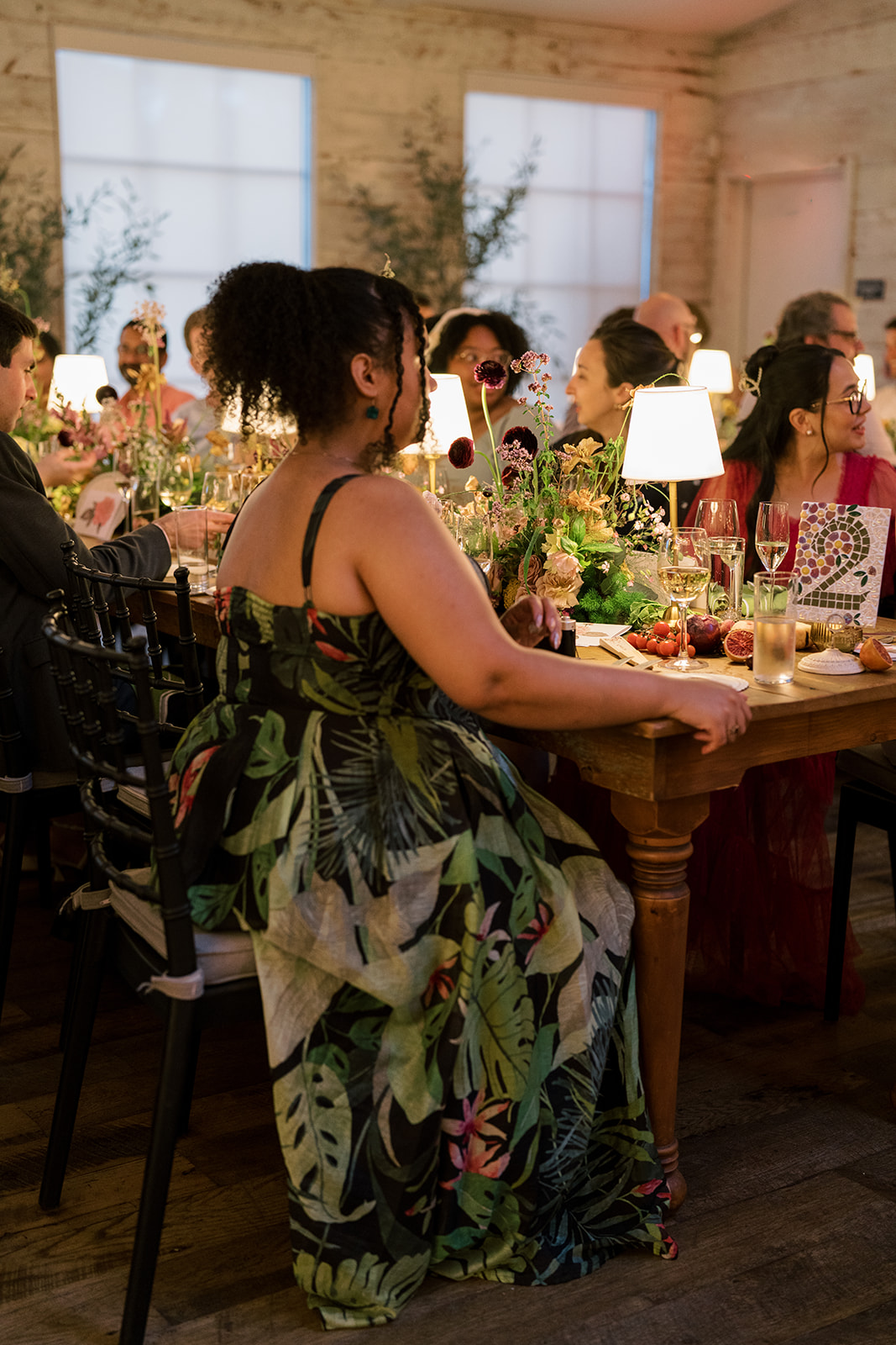 Wedding guest carrying a drink through the flower-filled reception