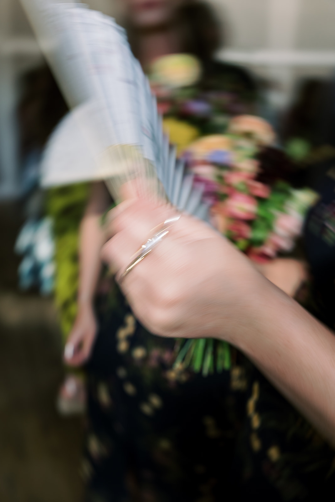 Close detail of a guest's bracelet and floral-patterned dress