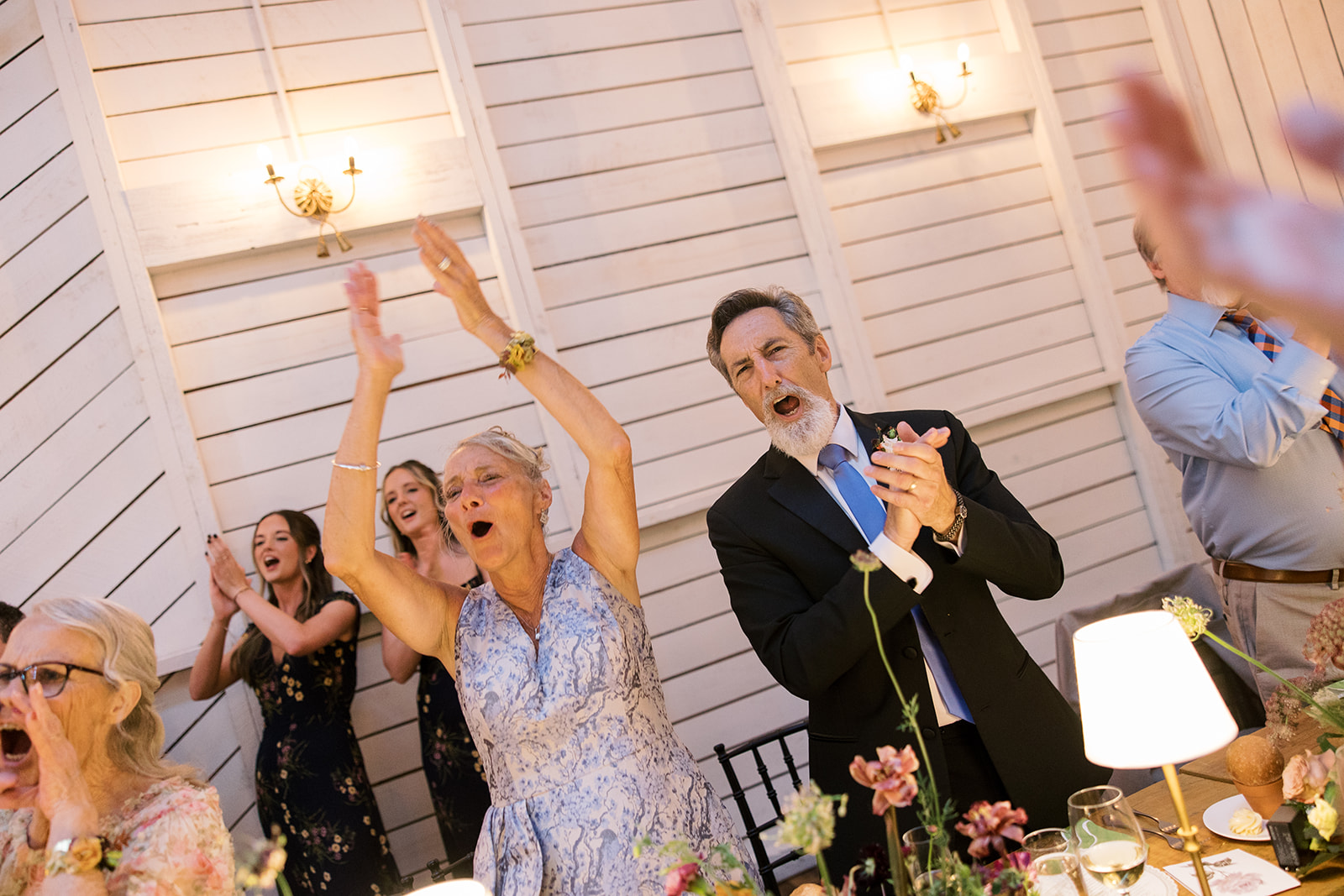 Wedding guests cheering during the reception