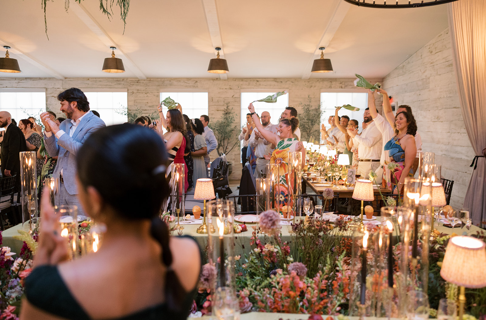 Wide candid view of guests inside the flower-filled reception