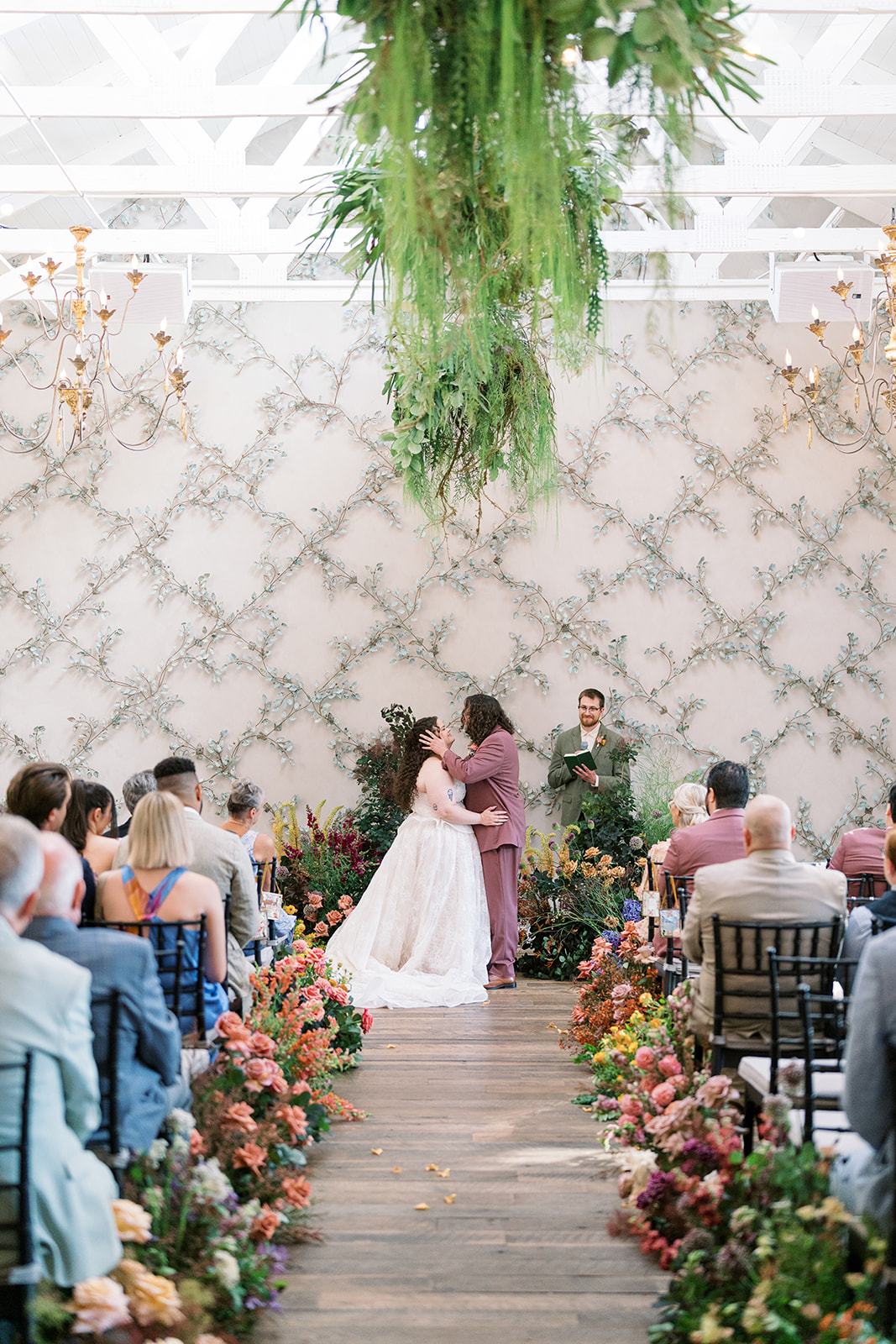Jeff and Breanna walking along the flower-lined ceremony aisle with guests seated on both sides