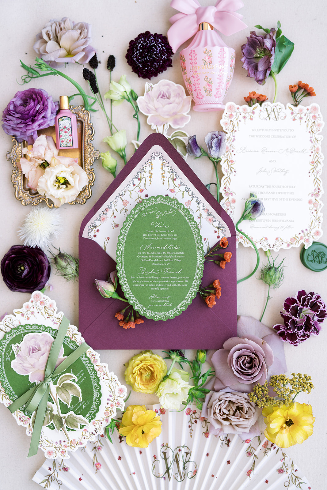Wedding stationery, fragrance and floral details arranged as a flat lay