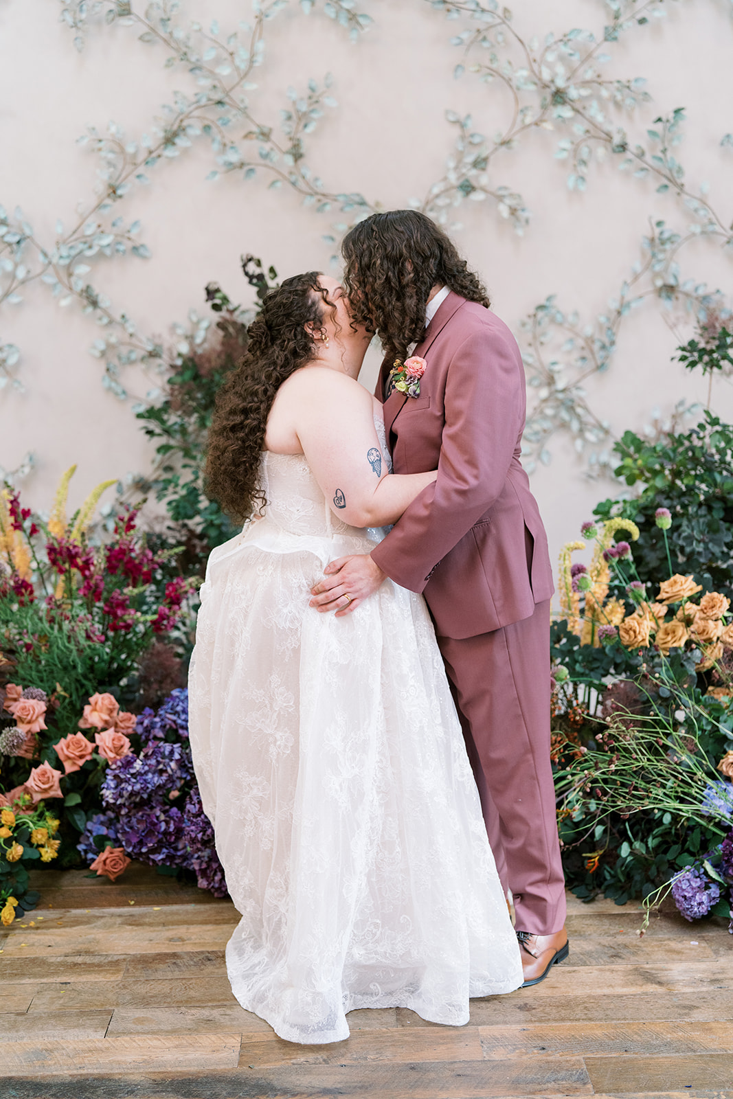 Jeff and Breanna kissing at the colorful ceremony backdrop
