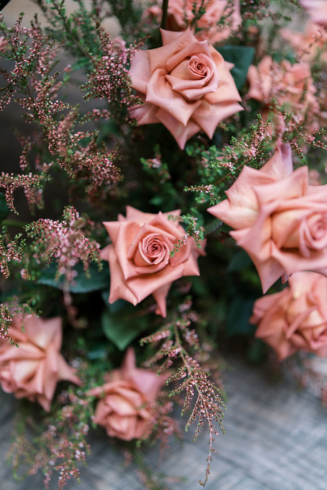 Dusty-rose flowers and textured greenery in the wedding florals