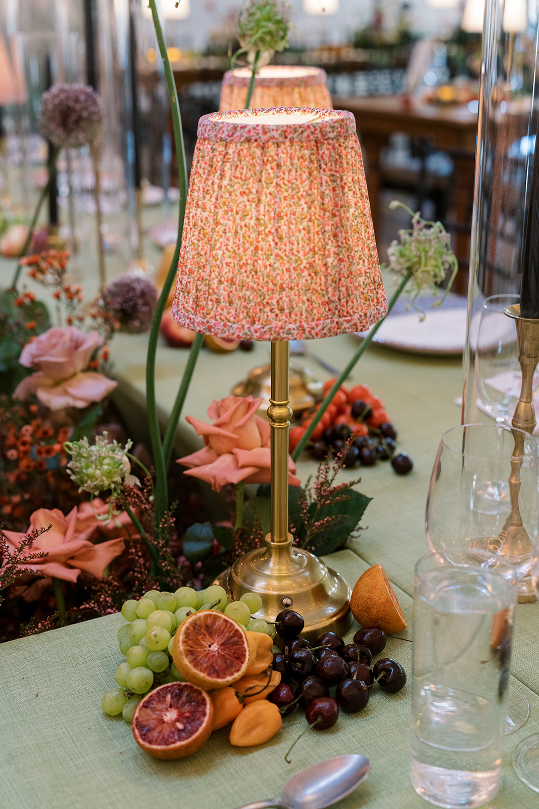 Reception table lamp beside fruit, flowers and glassware