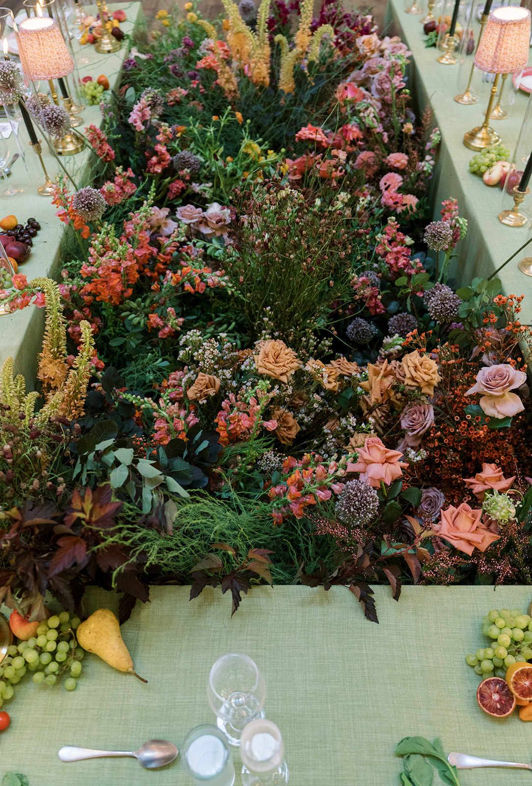 Dense floral runner across a green reception table