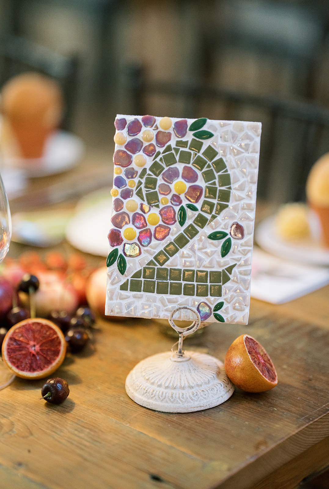 Table number two framed by colorful fruit and place settings