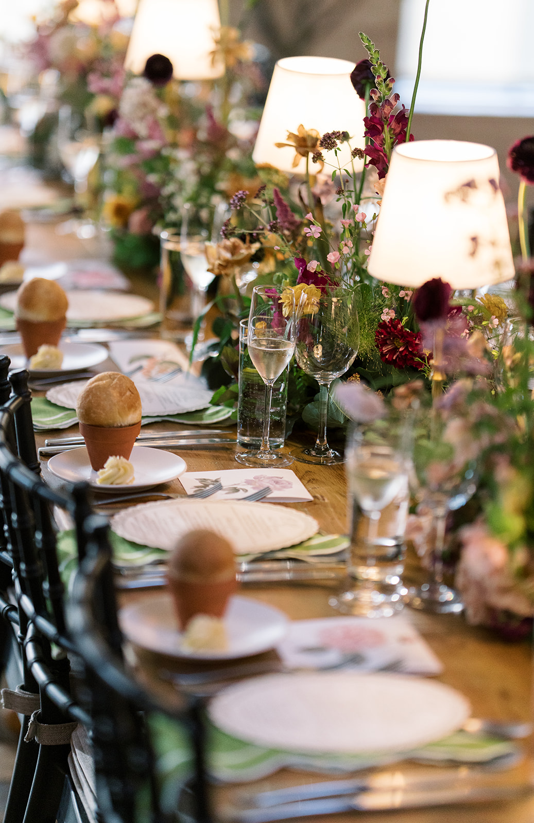 Layered place settings and flowers along the reception table
