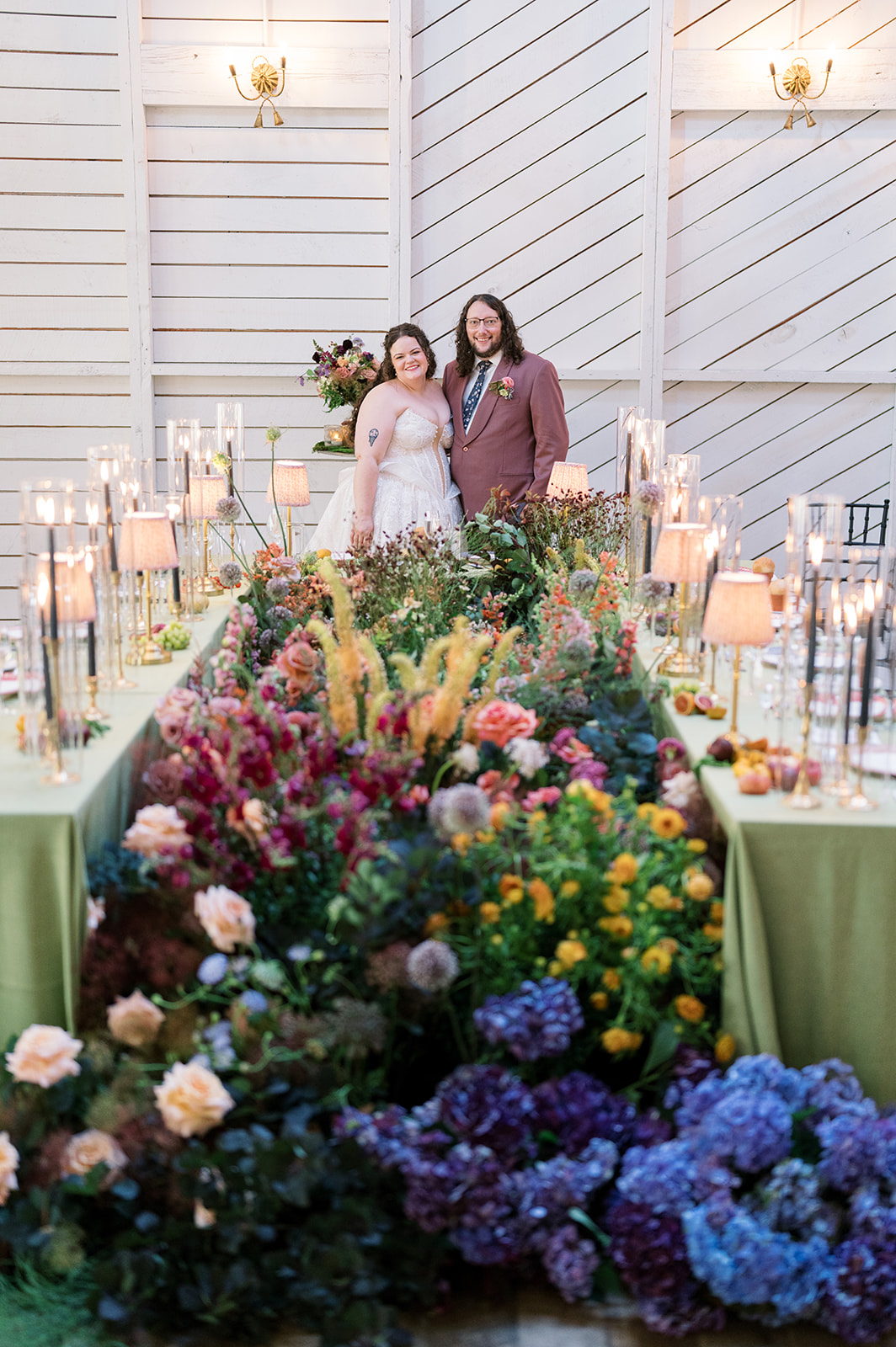 Jeff and Breanna standing together among the reception florals