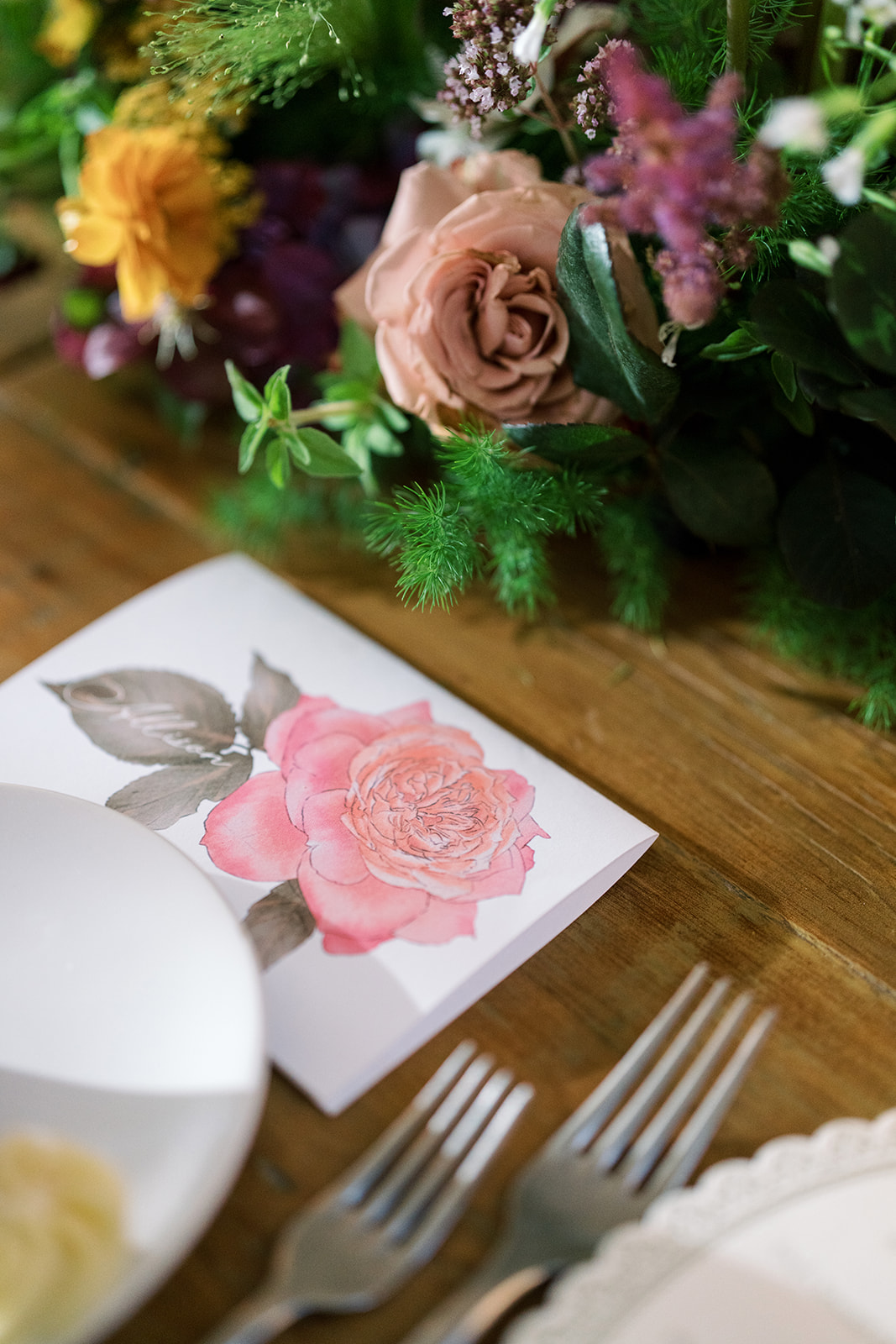 Botanical place card and floral detail at the reception table