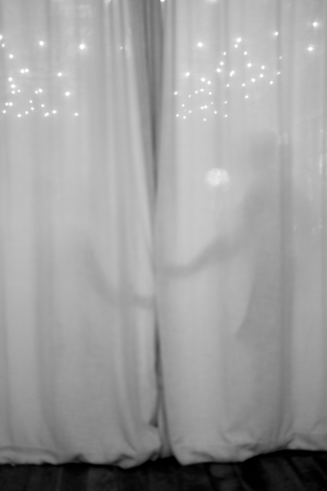 Soft curtain and string-light detail inside the wedding venue