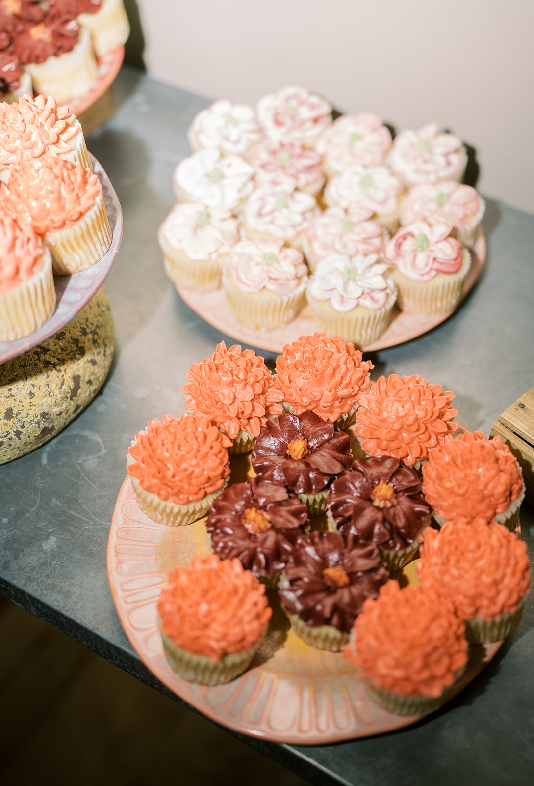 Pink and orange cupcakes arranged on the dessert table