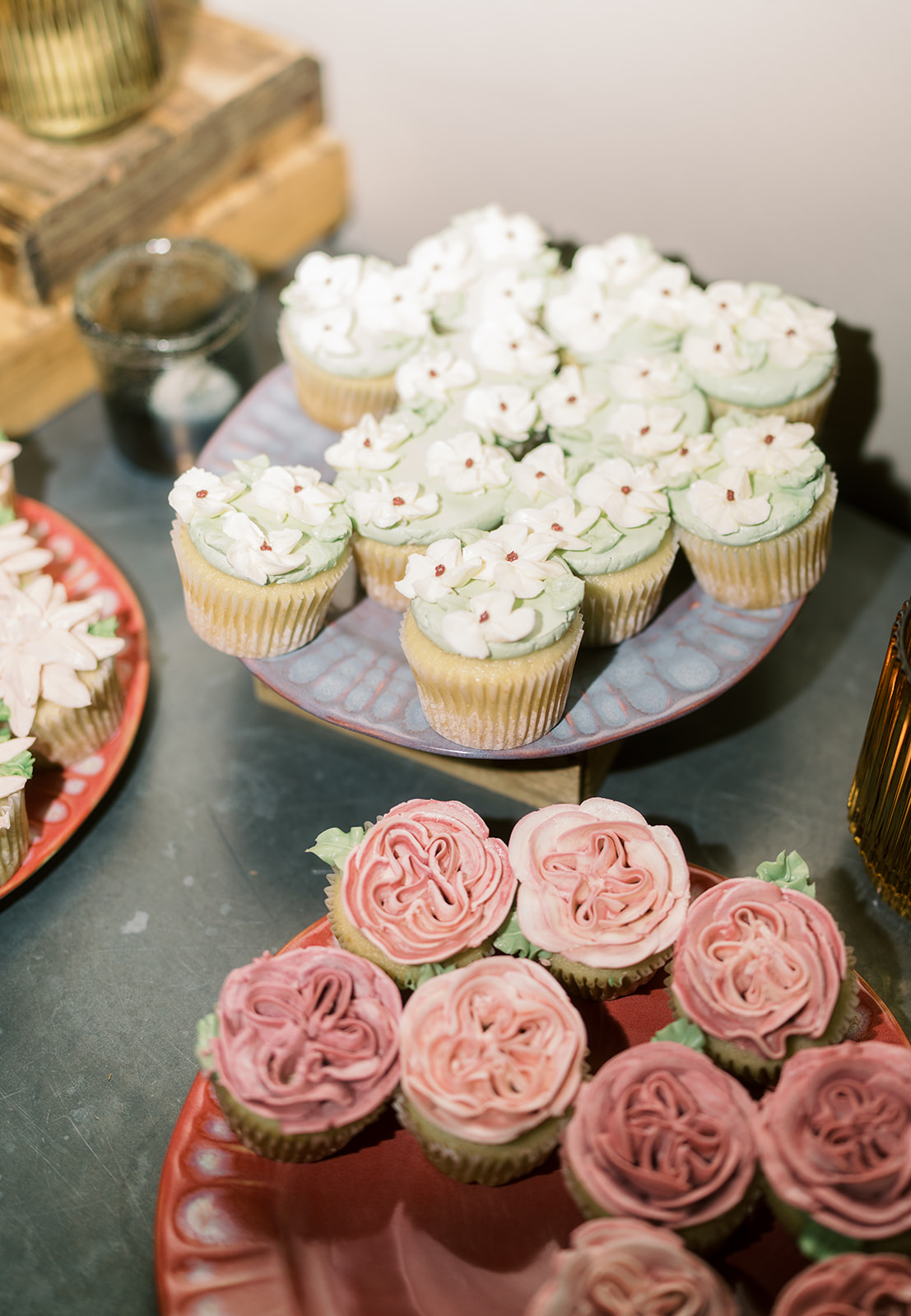White cupcakes with green sprinkles beside pink cupcakes