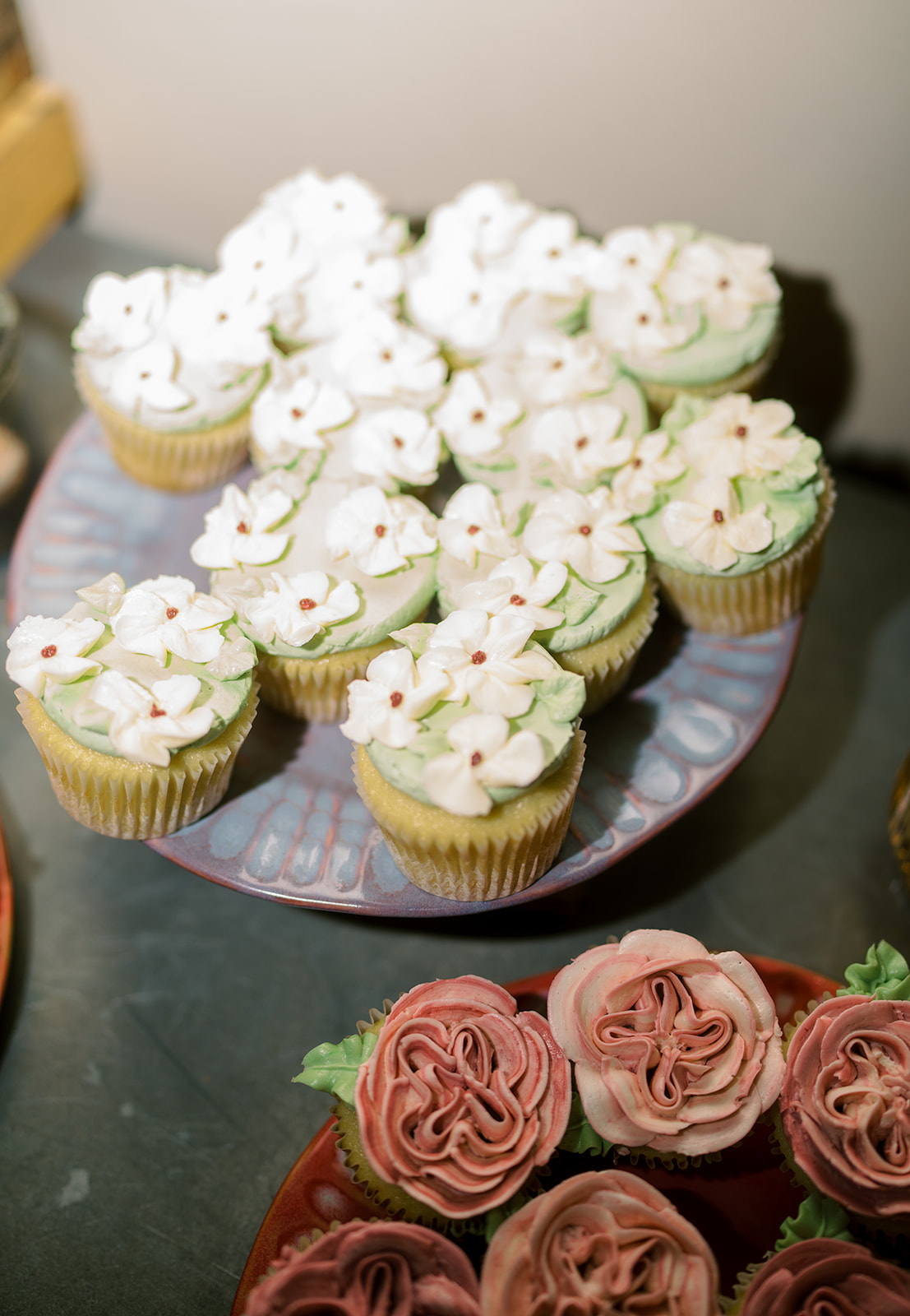 White cupcakes with green sprinkles and mauve frosting