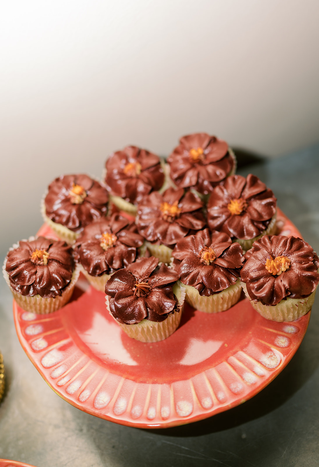 Chocolate cupcakes arranged on a red serving plate