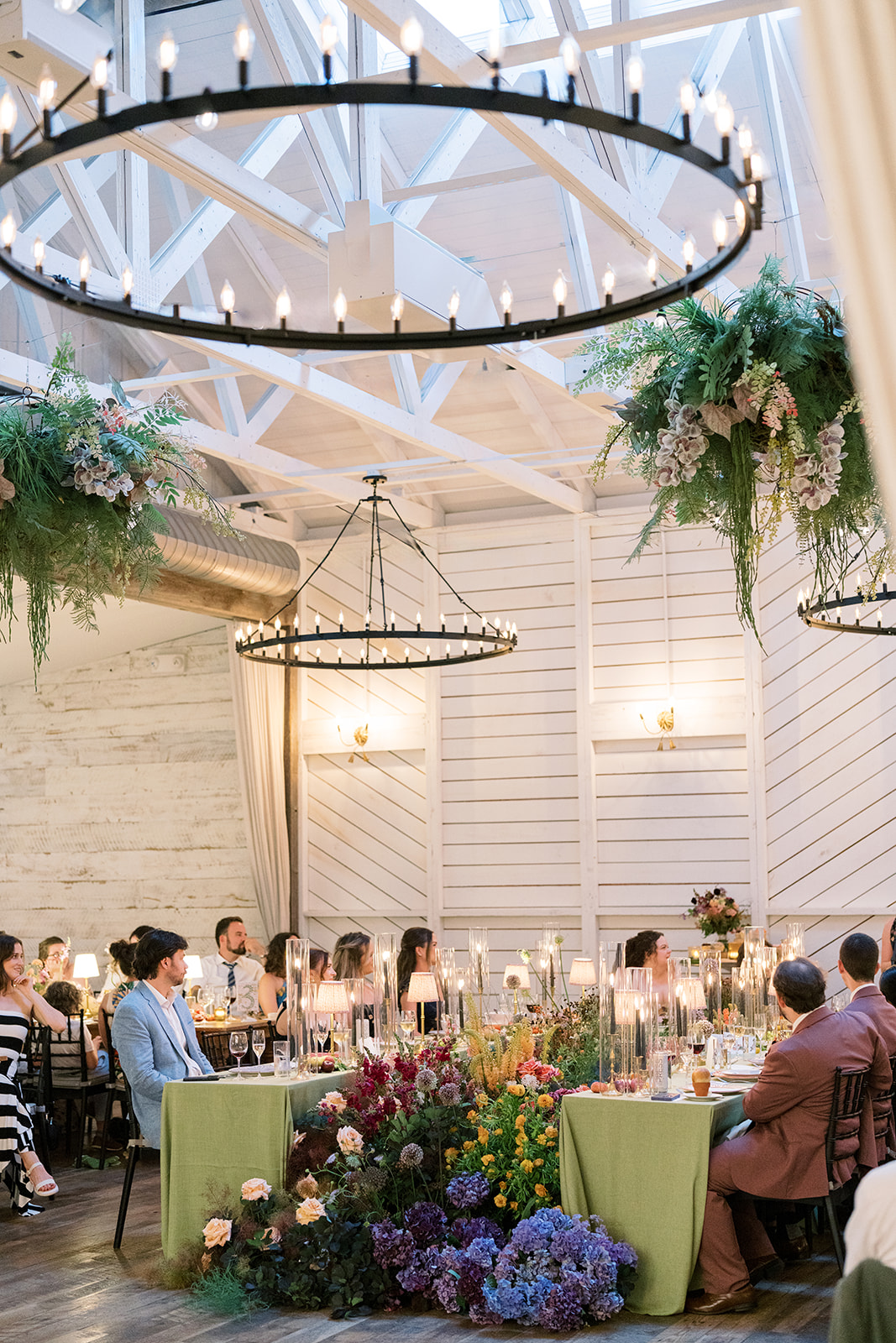 Wide reception view with guests beneath circular chandeliers