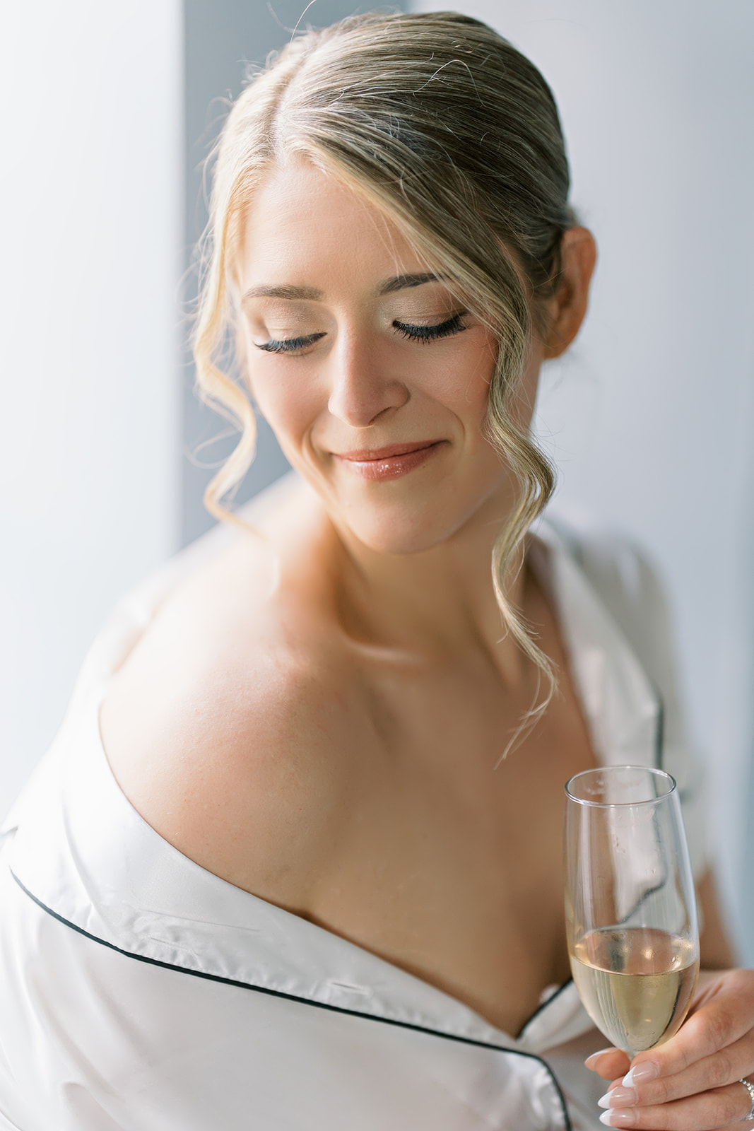 Caroline smiling with champagne before putting on her wedding dress