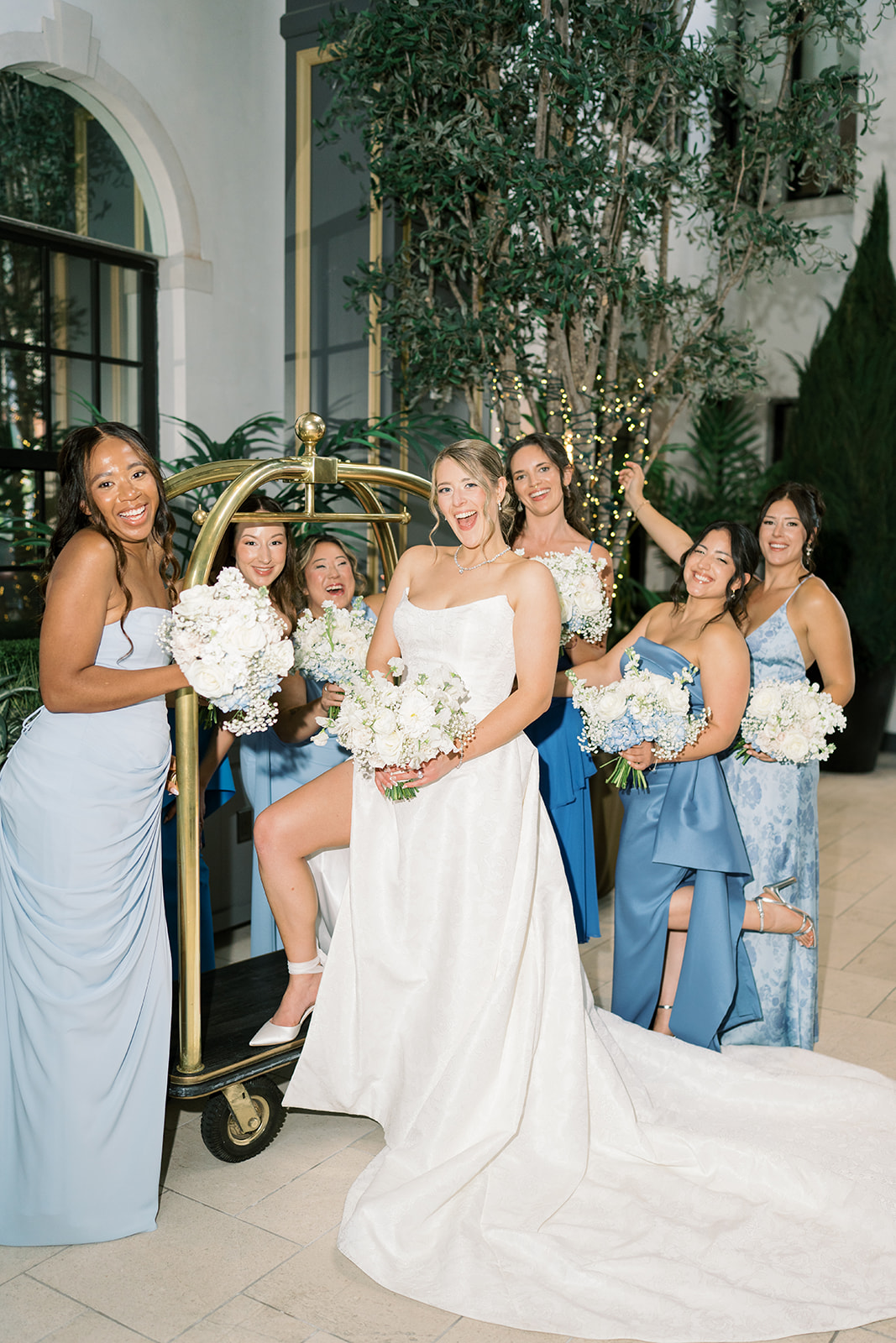 Caroline and her bridesmaids posing in the light-filled hotel atrium