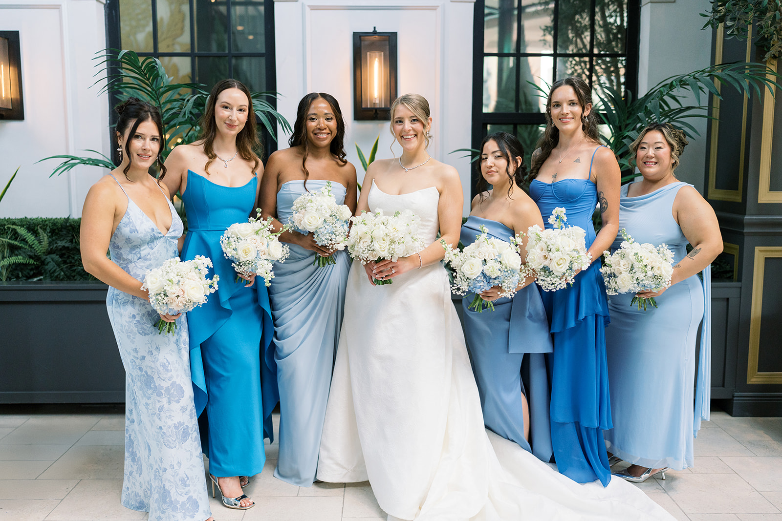 Caroline with her bridesmaids and white bouquets inside The Lytle Park Hotel