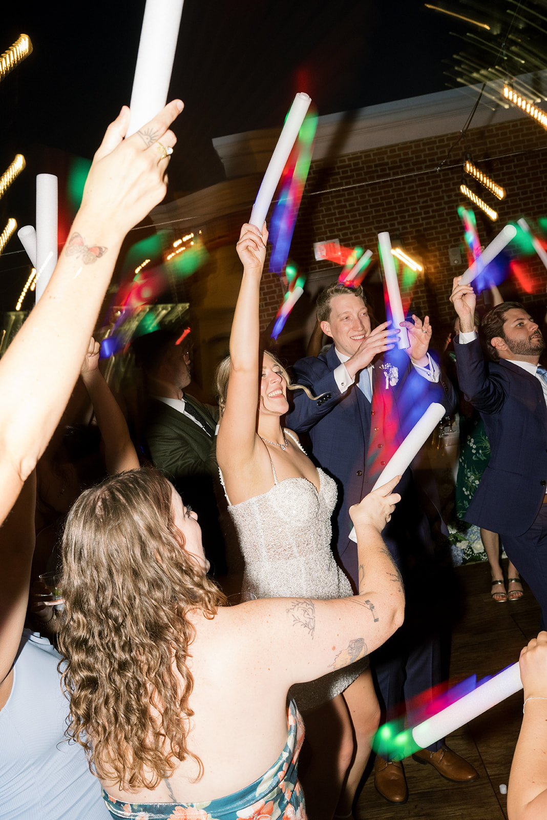 Guests dancing with glow sticks at Joey and Caroline's wedding reception