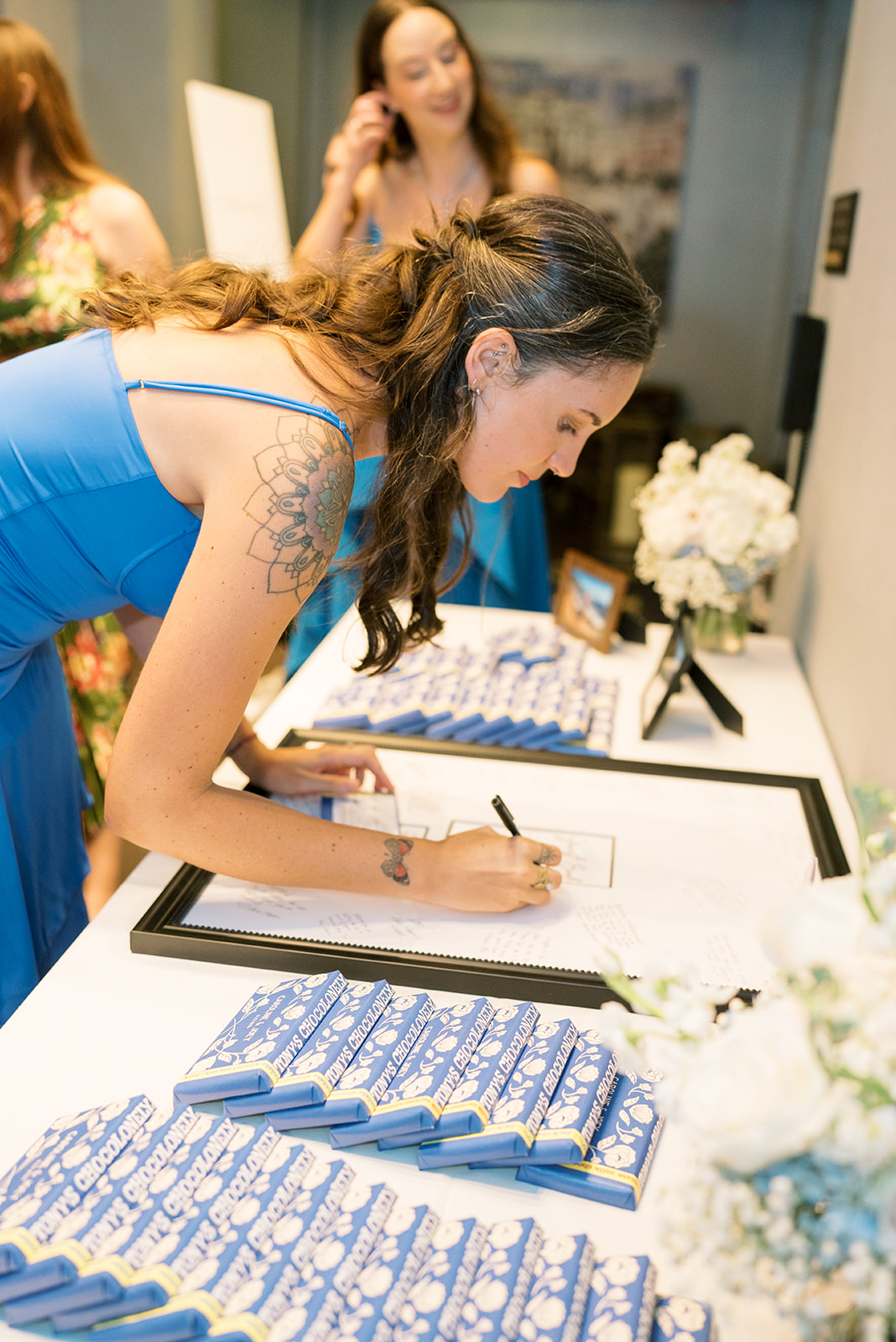 A wedding guest signing the guest book at Joey and Caroline's reception