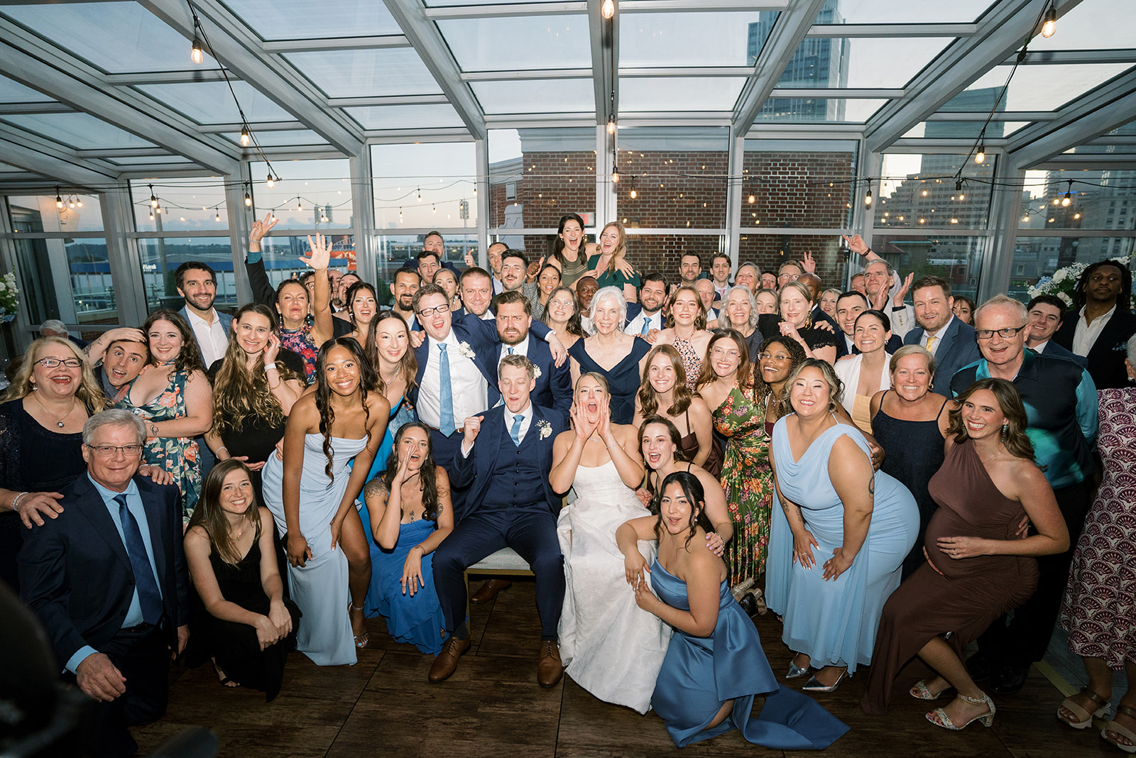Joey and Caroline surrounded by wedding guests during the reception