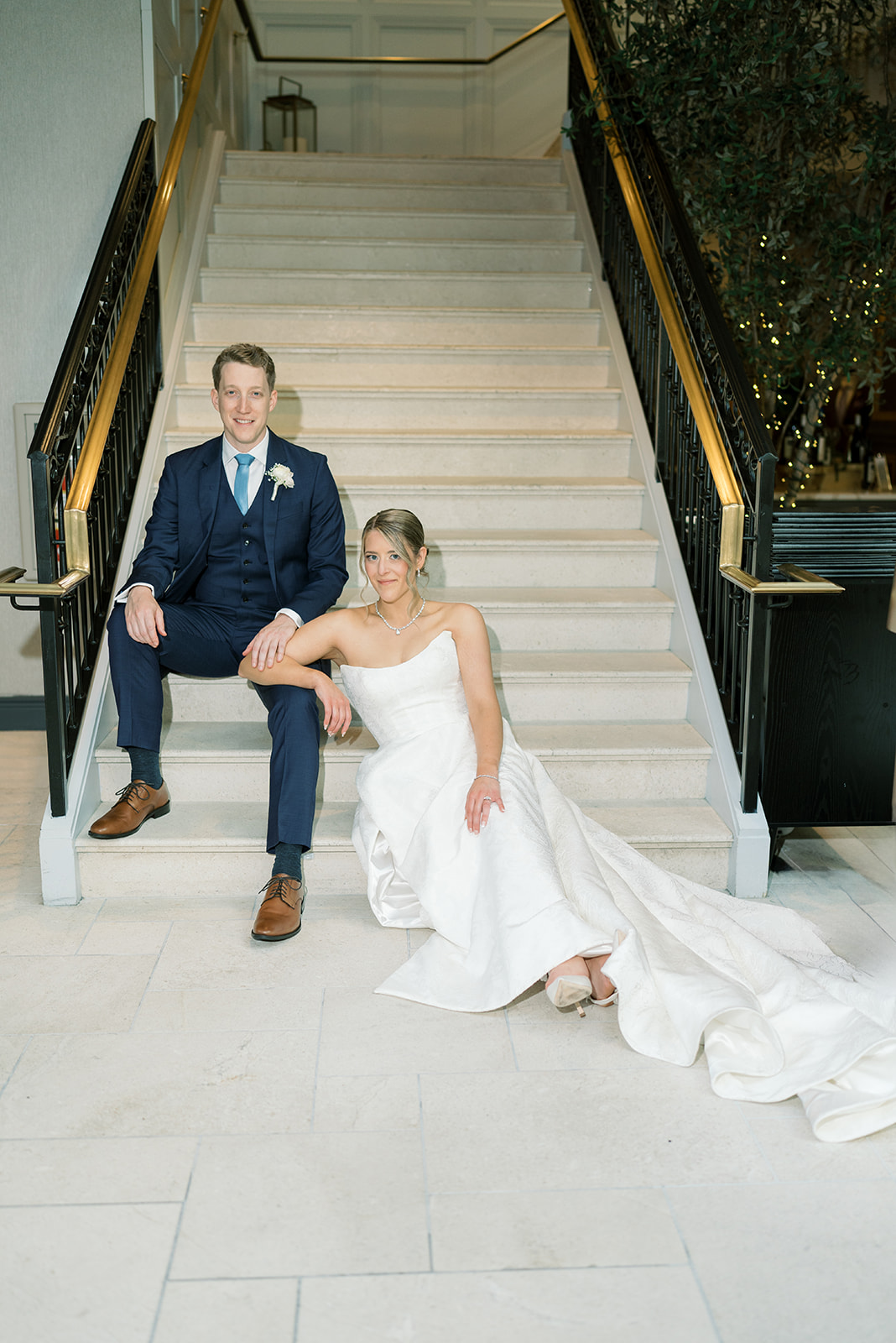 Joey and Caroline seated together on the hotel staircase after the ceremony