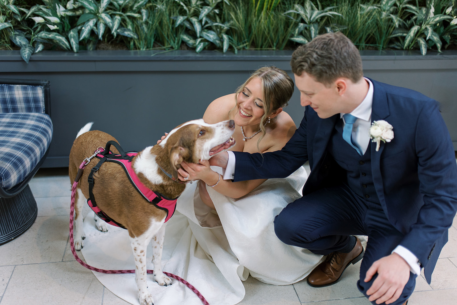 Joey and Caroline kneeling with their dog during wedding portraits