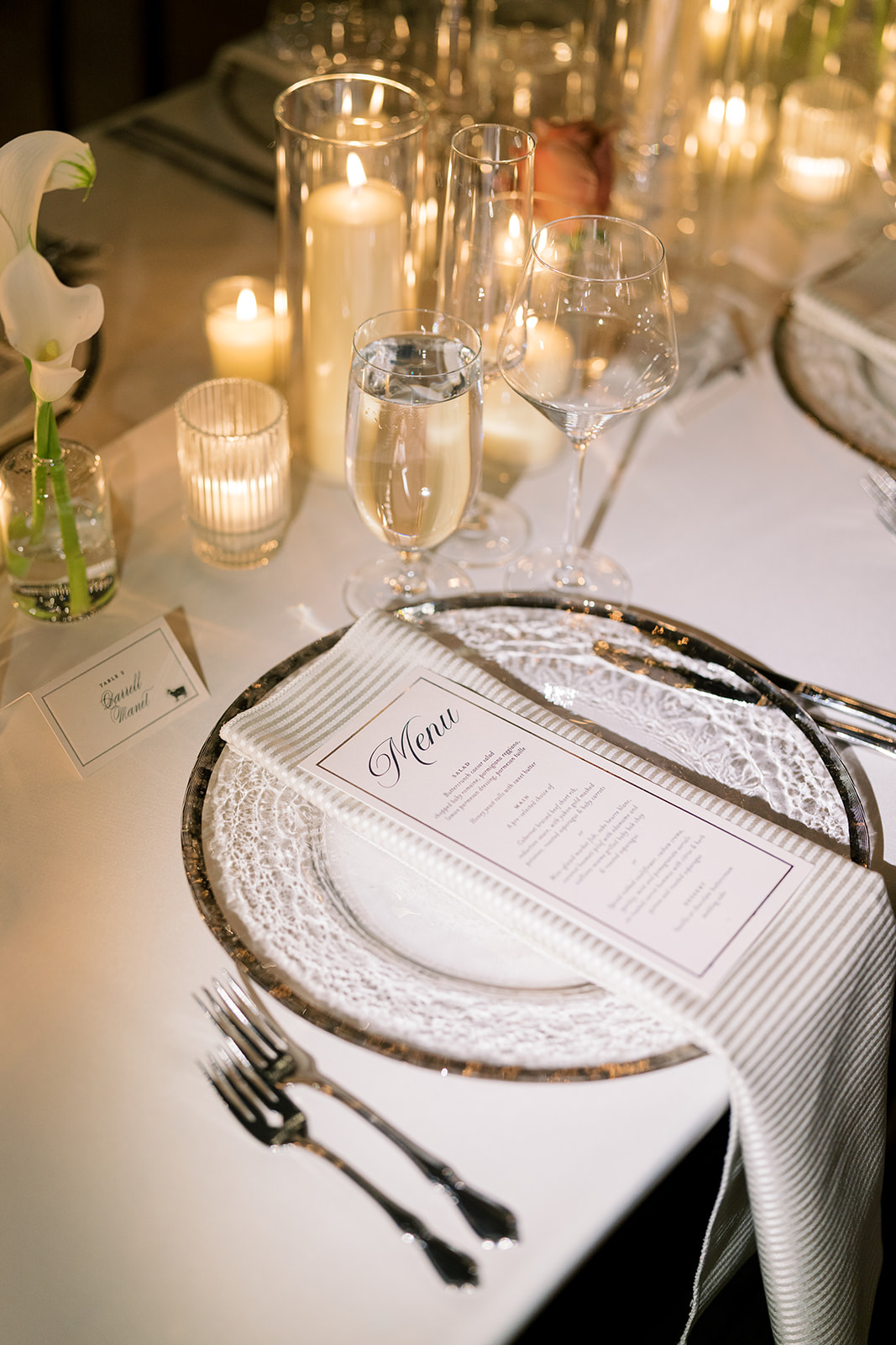 Layered reception place setting illuminated by candlelight