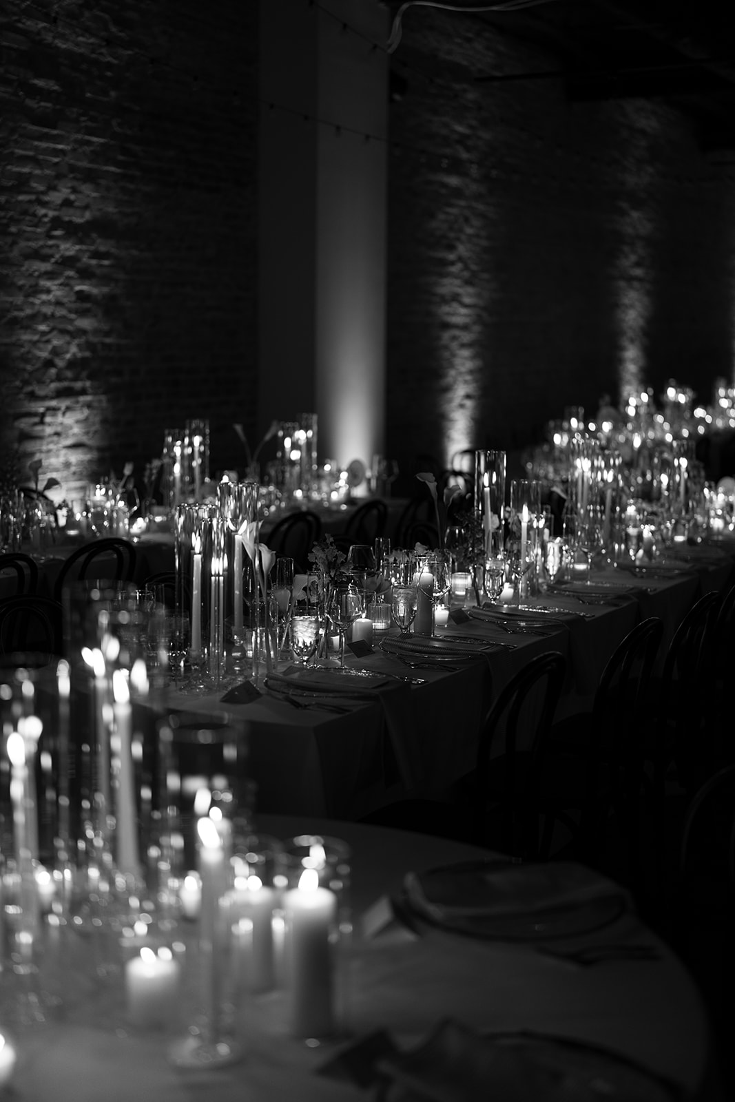 Black-and-white view of candlelit reception tables inside The Spot on West Fifth