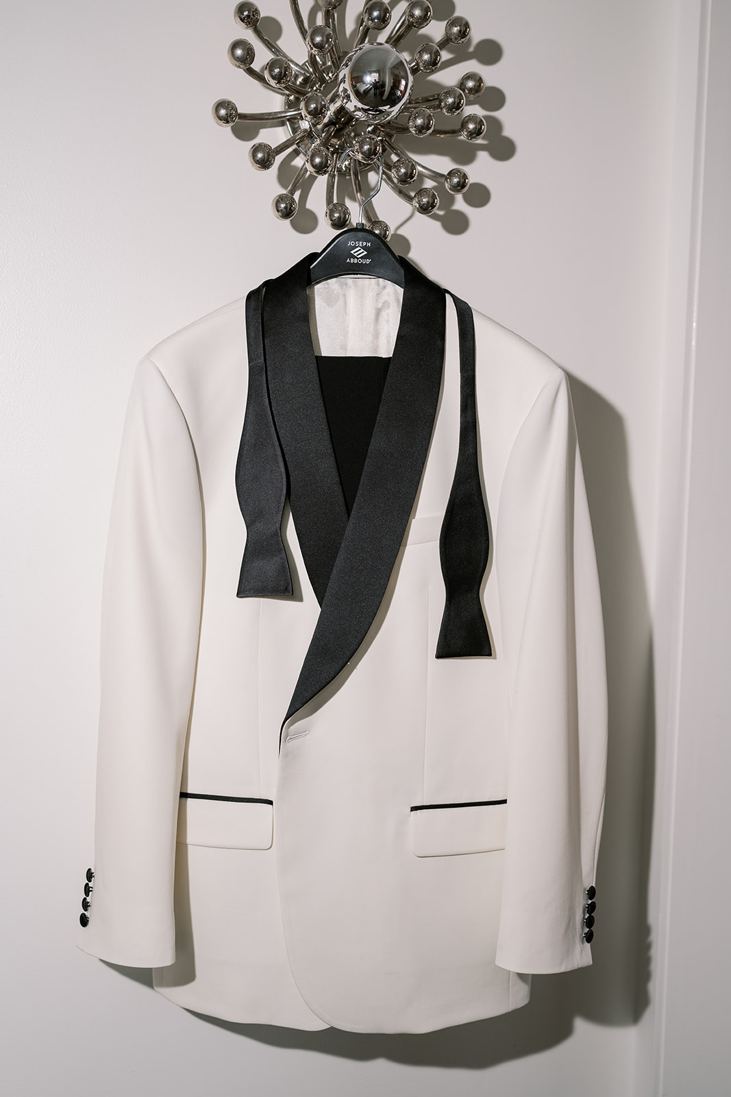Kevin's white dinner jacket hanging beside contemporary artwork during getting ready at 21c Museum Hotel Cincinnati