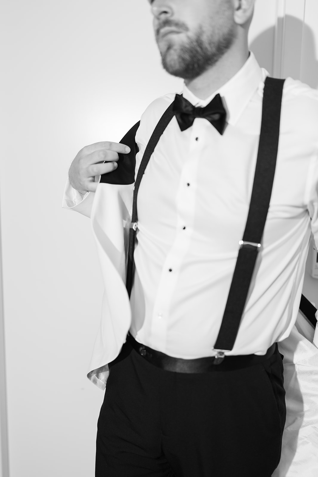 Kevin in suspenders and a bow tie while getting ready for the wedding