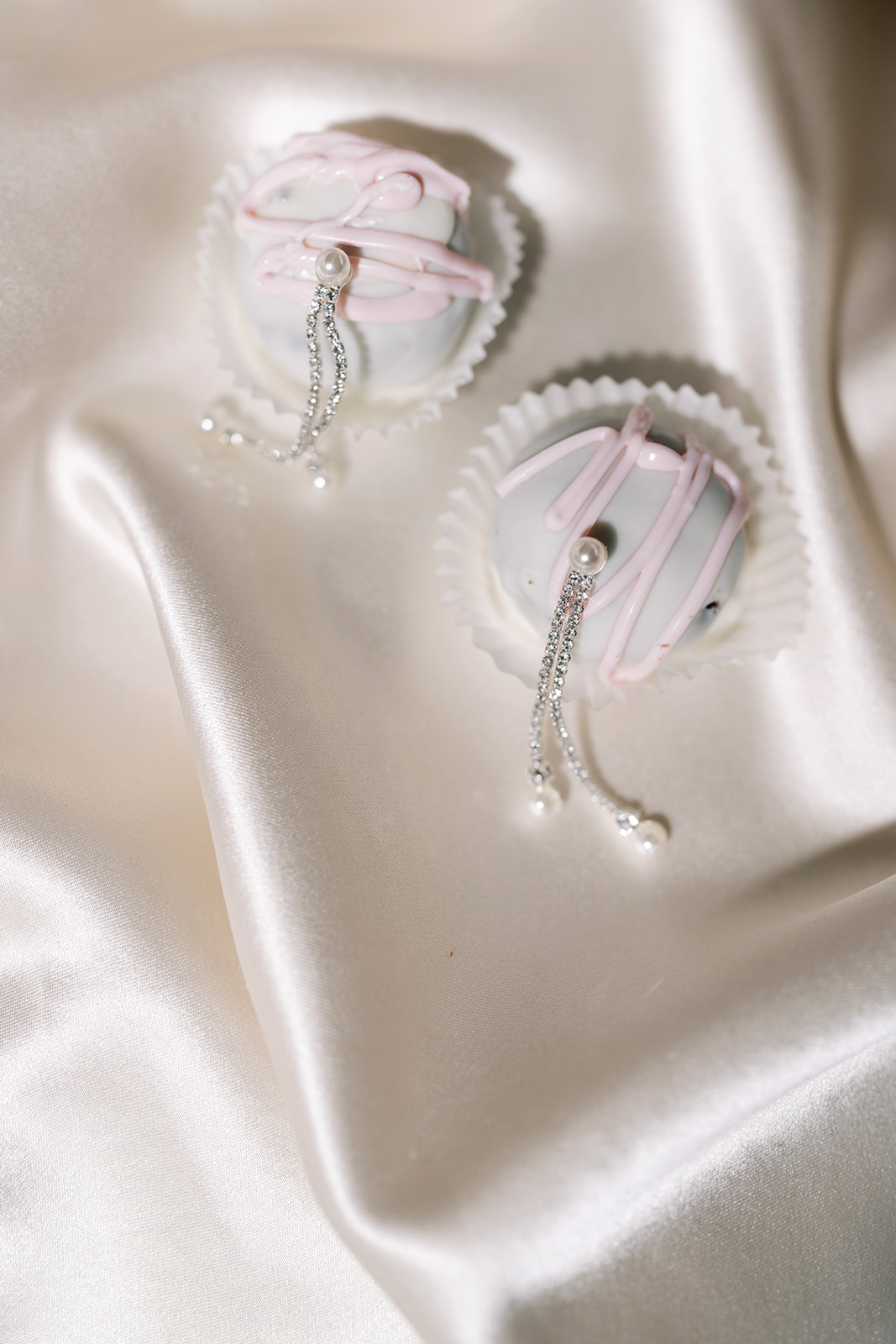 Meghan's bridal earrings photographed on ivory satin