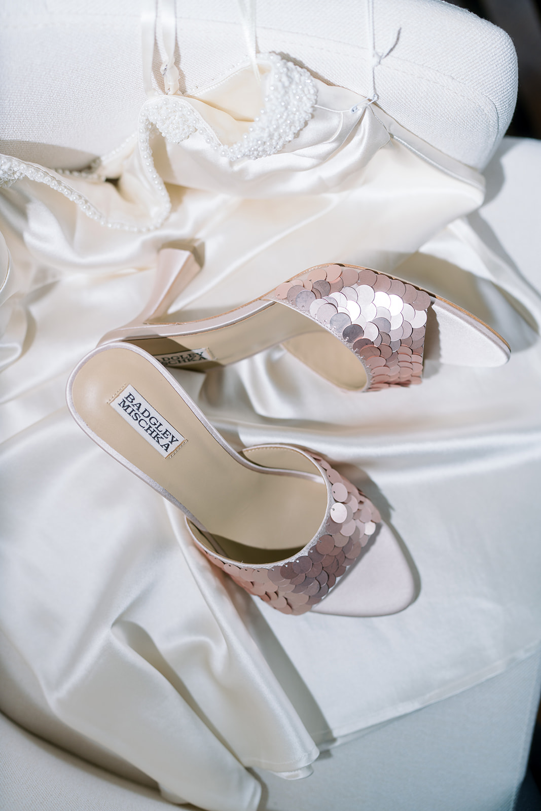 Meghan's crystal-bow wedding shoes arranged on ivory satin