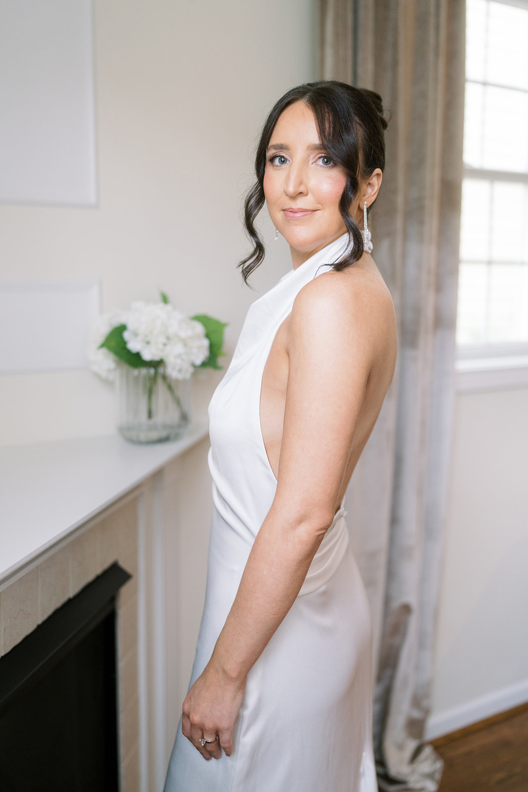 Meghan looking over her shoulder in a bright getting-ready room
