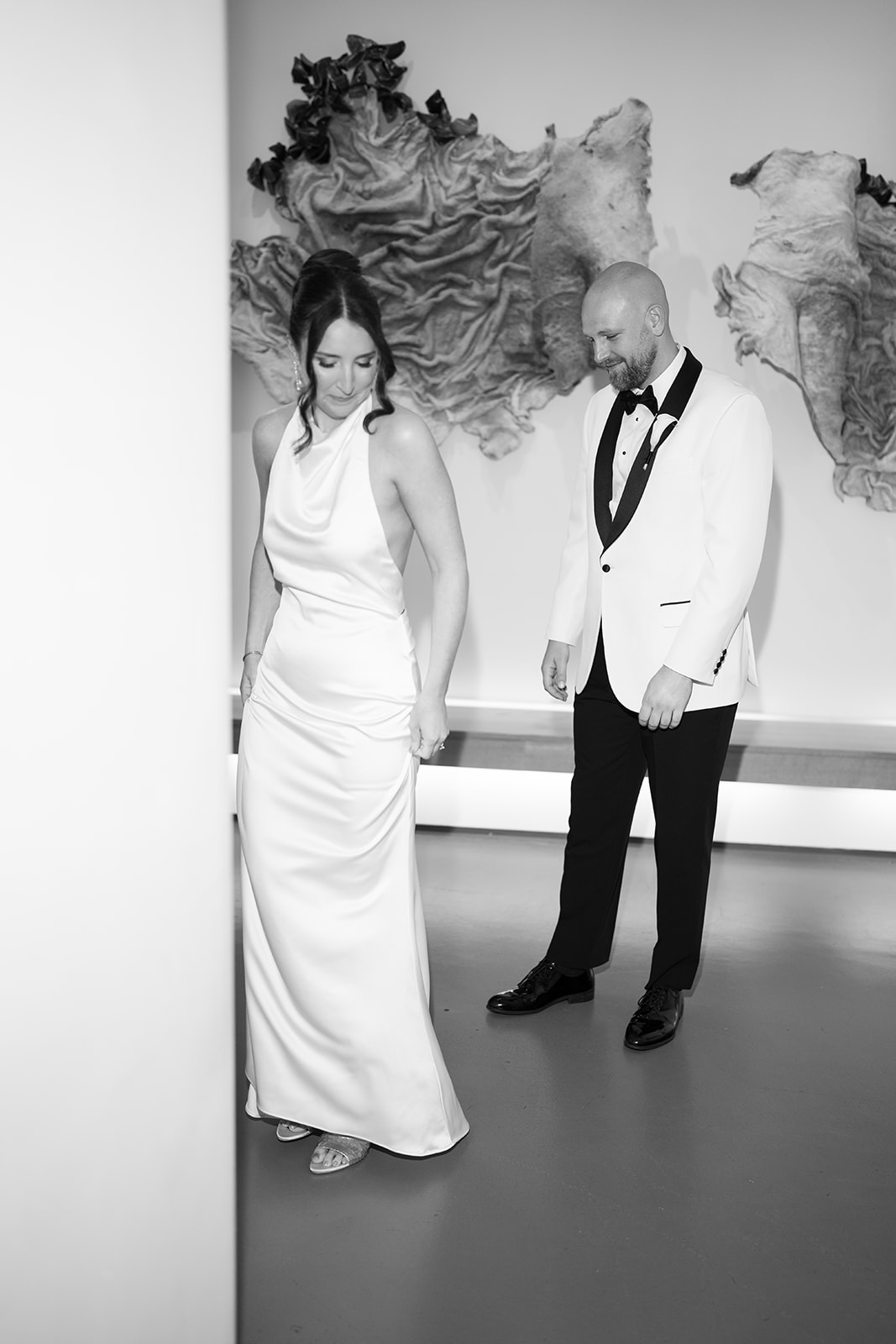 Black-and-white portrait of Meghan and Kevin together beside contemporary artwork